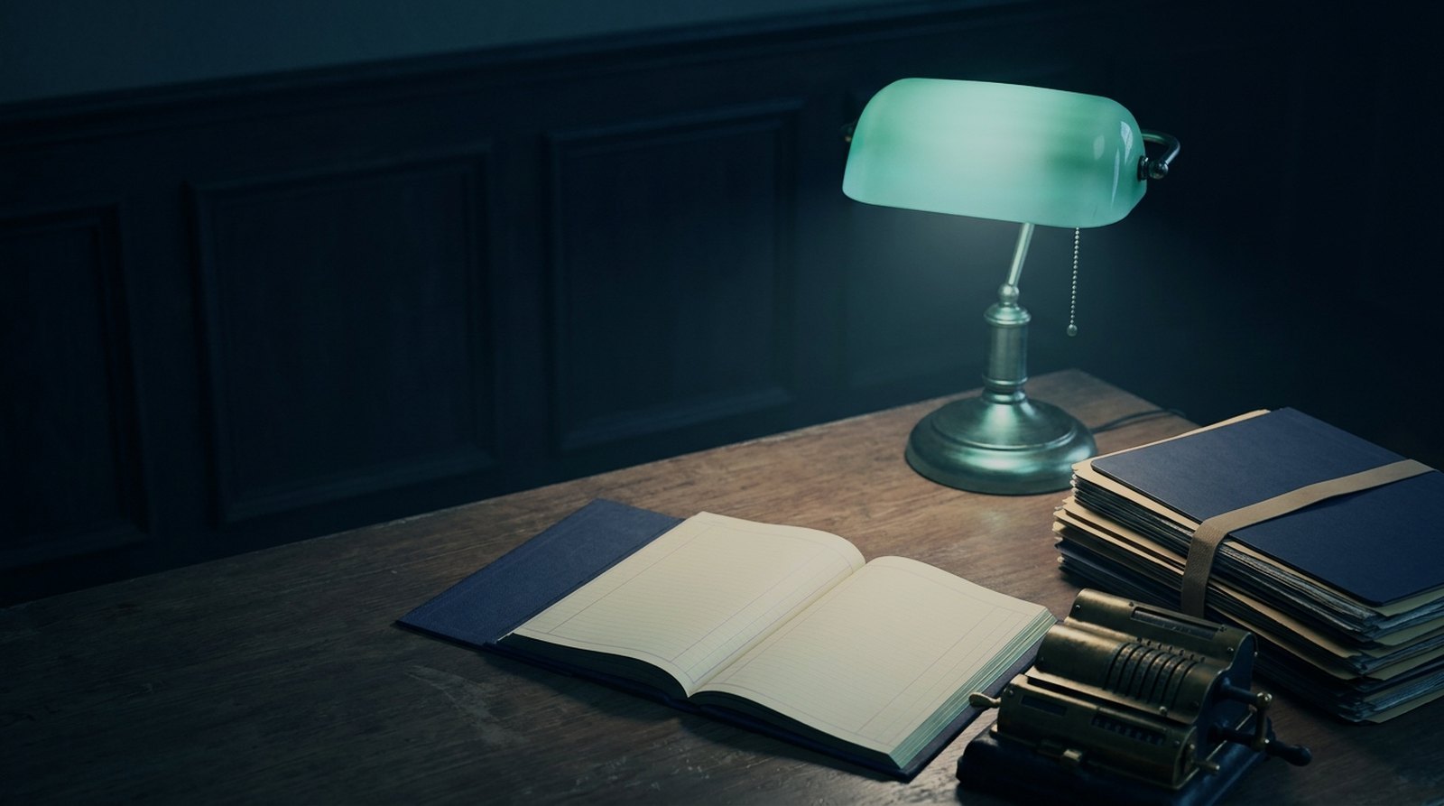 Collections desk under a green banker lamp with an open ledger and banded account folders