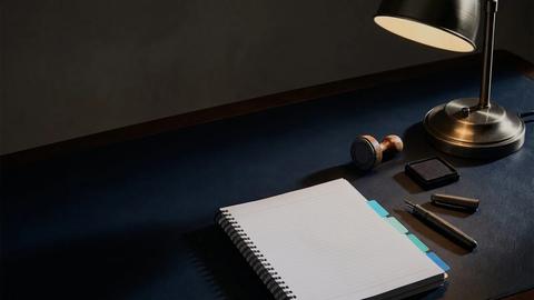 An open notebook and pen, drafting a request for proposal