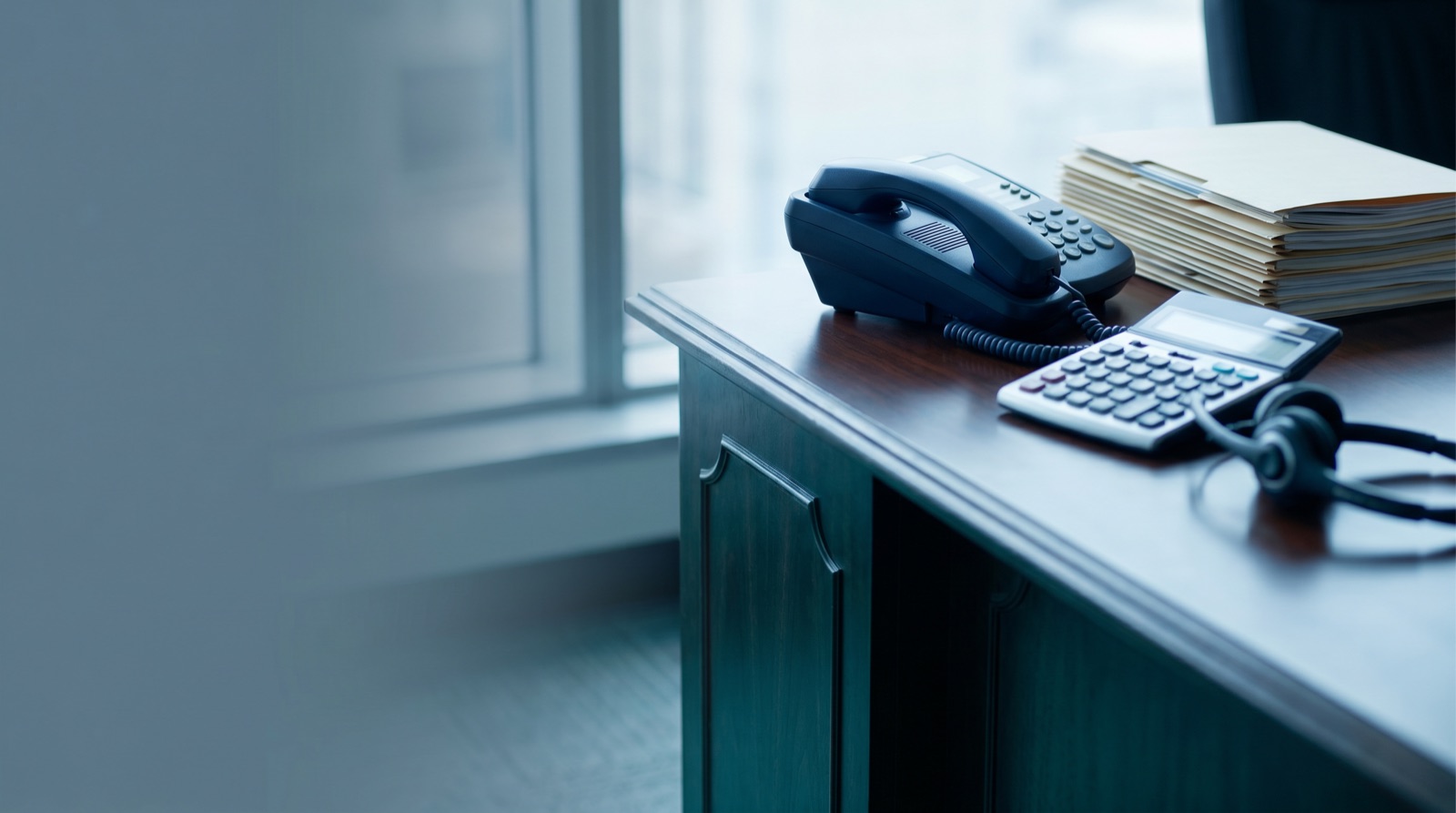 Empathetic debt collection agent on phone in modern call center bay